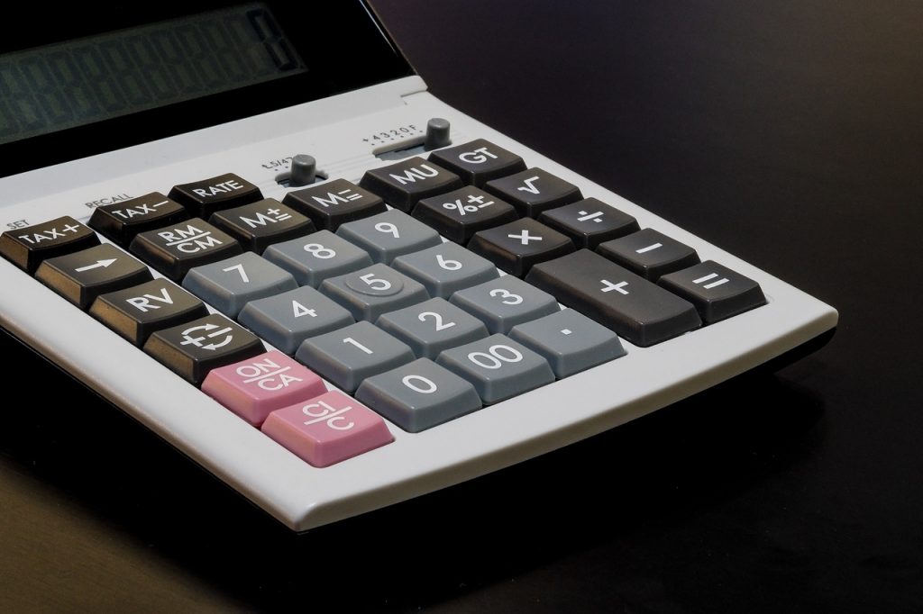 Kalkulator biurowy leżący na czanym stole