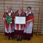 Trzy starsze kobiety jedna z nich trzyma kartkę