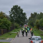 rajd-rowerowy-2021-07 Ucszstnicy rajdu rowerowego jadący przez ulice gminy oraz podczas poczęstunku na mecie.
