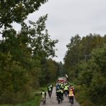 rajd-rowerowy-2021-08 Ucszstnicy rajdu rowerowego jadący przez ulice gminy oraz podczas poczęstunku na mecie.