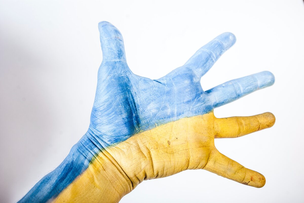 wyciągnięta dłoń . Pomalowana w barwy Ukrainy niebiesko-żółte