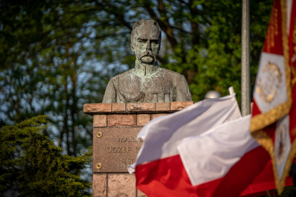 Popiersie Marszałka Józefa Piłsudskiego na czerwony tle