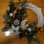 412 Pleciony wianek ozdobiony srebrnymi bombkami, szyszkami, pomarańczami, cynamonem, białą gwiazdą betlejemską.