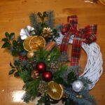 418 Biały wianek ratanowy w zimowej kolorystyce wykonany z jodły świerku, przyprószonych gałązek śniegiem, białych i czarnych bombek