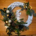 429 Pleciony wianek ozdobiony złotymi i czarnymi bombkami, zielonymi gałązkami świerku, tui, szyszkami, cynamonem i pomarańczy.