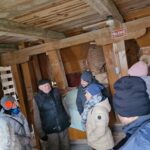 Grupa ludzi w środku drewnianego młyna