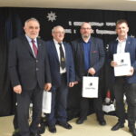 107 Trzech mężczyzn siedzi przy stole który jest przykryty czarnym suknem