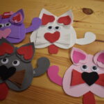 184 Dziewczynki przy stole kroją ser żółty, wędlinę reszta ugniata ciasto w blaszkach.