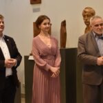 Grupa 4 osób stojących obok siebie - dwie kobiety i dwóch mężczyzn. Jedna z kobiet trzyma dyplom.