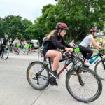 Rowerzyści jadący asfaltowa drogą