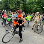 Rowerzyści jadący asfaltowa drogą