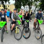 Rowerzyści jadący asfaltowa drogą