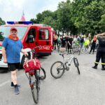 Rowerzyści jadący asfaltowa drogą