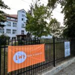 pomaranczowy material obok tablica z plakatami