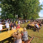 stoły i ławki zajęte przez ludzi