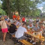 stoły i ławki zajęte przez ludzi