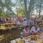 stoły i ławki zajęte przez ludzi