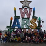 155 Na tle świątecznego napisu WARSZAWA grupa dzieci pozuje do zdjęcia