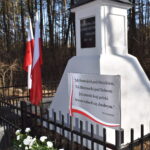 DSC_0001 Na obrazku czarne metalowe ogrodzenie, które kontrastuje z białymi kwiatami rosnącymi tuż obok niego. Te ukryte białe kwiaty dodają uroku i naturalną elegancję surowemu wyglądu ciemnego płotu.