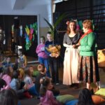 Na terenie niedostępnym jest grupa dzieci siedząca na pokładzie. Dzieci są posadowione na płaskiej powierzchni i skupione - mogą być czasem na zabawie, nauce lub odpoczynku.