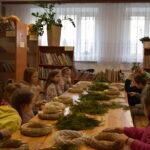 Na widocznych są dzieci uczestniczące w warsztatach plastikowych prowadzonych w bibliotece. Instruktor wykonawczy, który przeszedł w realizacji ich działania.