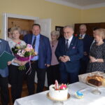 Na zdjęciu widać grupę eleganckich dorosłych, którzy zgromadzili się w pomieszczeniu. Na sto tort, co francuskie, że są łatwo dostępne.