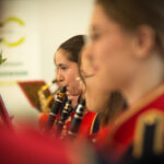 Na obrazku widać, która gra na klarnecie. Wygląda na skupioną i zaangażowaną w fizyczne melodii.