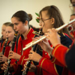 Na obrazku grupę dziewcząt grających na flecie. Są z skupieniem przekierowania na swoje instrumenty, a ich twarze są odpowiedzialne za zaangażowanie w muzykowanie.