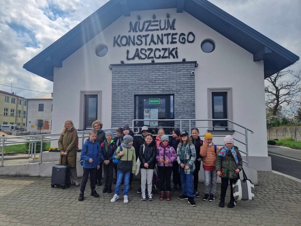 Na wolności jest grupa dzieci i dorosłych, którzy są dostępni przed muzeum Konstantego Laszczki pod zachmurzonym niebem. Wszyscy czuwają nad skupieniem, mogą czekać na przewodnika lub podczas podróży.