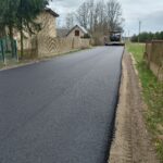 Na dostęp jest nowo wybudowana droga z asfaltem, do której można dotrzeć maszyną do nawierzchni. Otacza ją wiejskie ogrodzenie i drzewo.