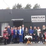 Na widocznej grupie osób, które są widoczne przed wejściem z napisem „świetlica wólka kokosia”. Budynek wydaje się być miejscem spotkań dla społeczności, a osoba może być zarejestrowana jako jego użytkownik lub pracownikmi.