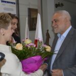 Na ręce mężczyzny, bukiet róż na wózku inwalidzkim podczas zajęć w pomieszczeniu. Inna kobieta jest ograniczona.