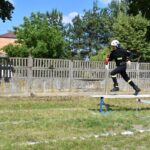 Na obrazku żołnierza i kasku biegnie po wyjściu z ćwiczeń szkoleniowych na zewnątrz. W tle widać drzewo i ogrodzenie.