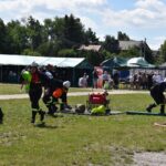 Na obrazie efektów podczas ćwiczeń terenowych, wykorzystujących węży i sprzęt do trawiastym użytkowania. W tle znajdują się namioty oraz widzowie ich działań.