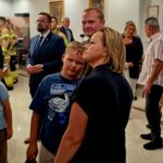 20240801_170846 Na obrazku widać grupę osób, zarówno dzieci, jak i dorosłych, którzy zgromadzili się w pokoju. Inne z nich są eleganckie, a w tle można je rozłożyć.