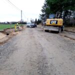 Na widocznym miejscu, w trakcie budowy, po prawej stronie, której stoina jest koparka. Obok dróg znajdują się dwa dodatkowe, a przy nich widoczni są pracownicy wykonujący jakiekolwiek zadania.