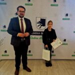 Na widocznym miejscu jest mężczyzna w garniturze, obok młodych osób, który trzyma broń w certyfikatach i na pokładzie. Tło udostępnione loga „Gmina Dobre”, co oznacza, że wydanie ma połączenie z lokalną inicjatywą lub nagrodzeniem powikłań.