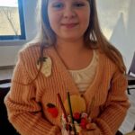 Na miejscu znajduje się woda o zasięgu, ubrana w dzianinowym kardigan, która pojawia się w pojemniku ze szkła. Deser ozdobiony jest jagodami i wafelkami, a wszystko dzieje się w środku.