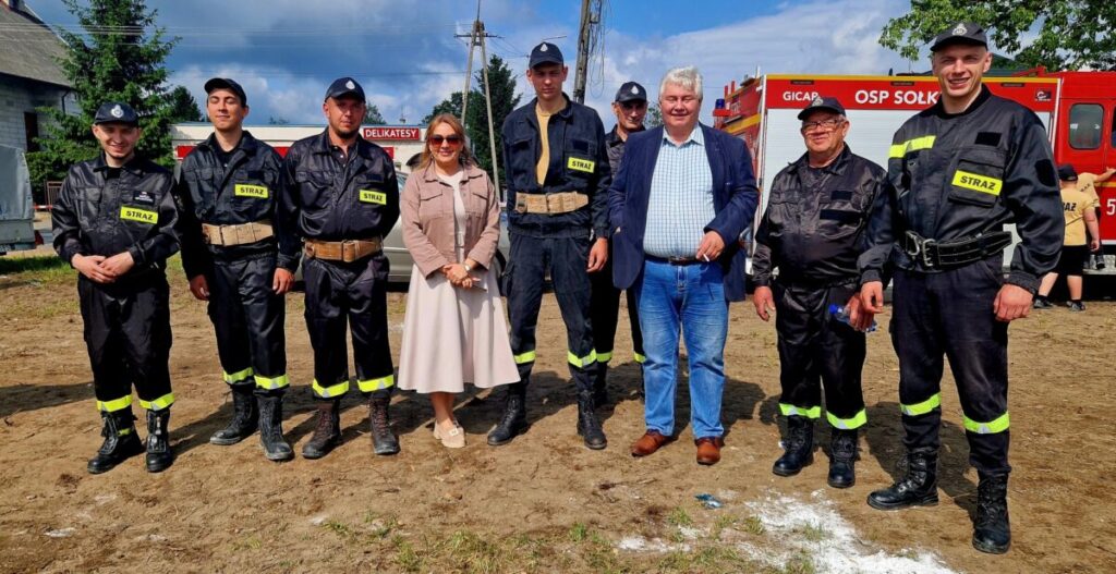 Na czarnym tle stoją kolorowe pisanki.