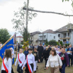 Wszyscy uczestnicy rajdu pozują do zdjęcia za nimi zielony namiot i wysokie drzewa