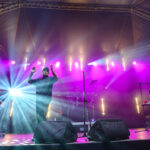 widok z góry na kwiatek doniczkowy, zapakowany prezent i ręce wycinające nożyczkami serce z papieru