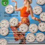 Plakat promuje Potańcówkę Retro z kobietą w pomarańczowej bluzce. Tło niebieskie z monetami i tekstem. Kolorowe detale ożywiają całość.