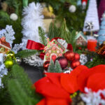 Kolorowe ozdoby świąteczne na choince: domki z piernika, czerwone bombki, zielone gałązki. Tło w zieleni i czerwieni.