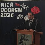 636661724_931741475868041_3062539801191386776_n Mężczyzna w garniturze przemawia przy podium. Tło jest ciemne z napisem ROCZNICA POD DOBREM 1831-2026 i białymi oraz czerwonymi kwiatami. Na podium ilustracja z wizerunkiem historycznym.