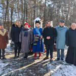 637902464_931741039201418_4029668158810991897_n Grupa ludzi stoi na śnieżnym tle lasu. Jedna osoba ubrana jest w niebieski, historyczny strój z piórami. Reszta w zimowych płaszczach, przy nich flagi.