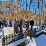 638712347_931740415868147_5089242940306672189_n Grupa ludzi w zimowych ubraniach stoi przy pomniku w lesie, otoczonym śniegiem. Drzewa w tle w słoneczny dzień. Uczestnicy trzymają wieńce.