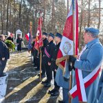 640717585_931740059201516_7771104880761732818_n Ceremonia na zewnątrz, osoby w mundurach trzymają flagi. Jasna, zimowa sceneria z ośnieżonymi drzewami w tle. Ludzie składają wieniec przy pomniku.