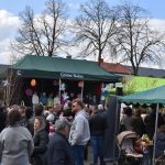 Na zdjęciu widoczny jest tłum ludzi pod zielonym namiotem z napisem Gmina Dobre. W tle stoi scena z grupą dzieci. Niebo jest częściowo zachmurzone.