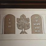 fMZRY11i Obraz przedstawia dwie kamienne tablice z numerami rzymskimi i drzewo pośrodku. Kolory to beżowy i biały. W tle widoczna jest biała ściana.