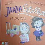 Okładka książki na pomarańczowym tle. Dwie dziewczynki są w centrum; jedna siedzi obok wózka, druga stoi z zabawką. Widoczne są napisy tytułu i autora.